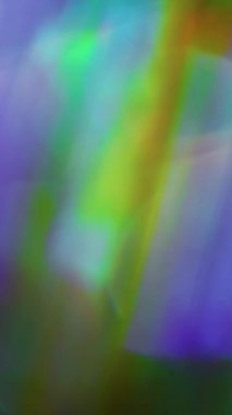 Dikey video. Işıldayan ışın. Odaklanamayan ışık soyutlaması. Bulanık bokeh arkaplanda çok renkli ışıltı parçacıkları ışıltı mercek parlamaları değişim hareketi.