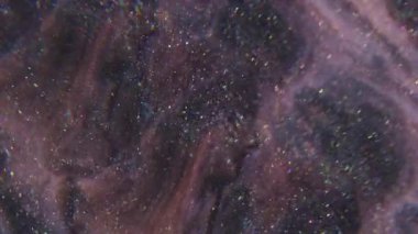 Parıldayan ışık. Sıçrama sıvısı. Soyut sanat arkaplanındaki pembemsi mavi boya kimyasal pigment parçacıkları.