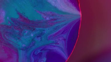 Mürekkep döküldü. Renkli karışım. Bulanık kırmızı neon yuvarlak doku akan mavi damlacıklar soyut arkaplanda süzülen parlak su.