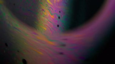Uzay bulanıklık küresi. Spektrum mürekkep sıvısı. Yağ deterjanı mercek çerçevesi etrafında akar. Pembe sarı renkli boya halkası. Kozmik siyah zemin..