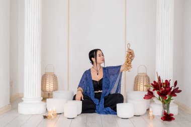 Şarkı kaseleri. İyi bir meditasyon. Kristal gürültüden hoşlanan kadın terapi çanı iyileşme tedavisi için mumları geri çekiyor..