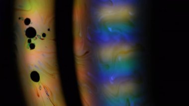 Odaklanamayan sıvı ışık. Renkli yağ. Mavi turuncu yeşil mürekkep, siyah suya karışıyor. Gradyan kemer soyut arkaplan.