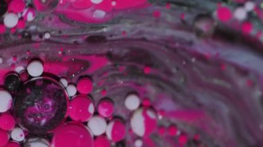 Mürekkep damlası. Akış karışımı. Odaklanmamış pembe beyaz yağ pigmenti su kabarcıkları soyut arkaplanda dönen ıslak damlalar.