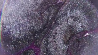 Mürekkep sıçraması. Parlak akıntı. Odaklanmamış mor gümüş rengi parlak doku soyut koyu siyah arkaplan üzerine yayılan parçacık akışı.