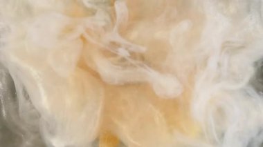 Parlak çiçek buharı. Işıl ışıl. Soyut sanat akrilik arka planında suya karıştırılmış sarı renkli doronicum bitkisi boyası.