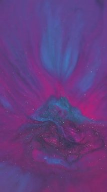 Dikey video. Boya patlaması. Bulanık boya karışımı. Yuvarlak renkli pigment damlası akrilik sıvıda dökülmüş. Pembe mavi neon parıldayan akış soyut arkaplan.