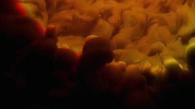 Ink mix. Color cloud texture. Defocused orange green pink splash rainbow vapor glitter water spreading on abstract dark black background.