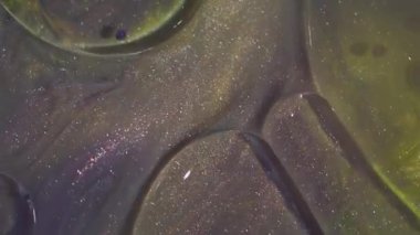 Jel mürekkebi. Kabarcık kolajeni. Söndürülmüş sarı mor renkli simli akrilik yağlı su soyut sanat arkaplanda ışıldıyor..