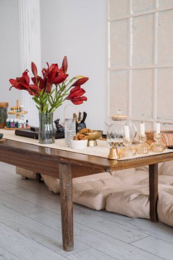 Yemek odası. Ev atmosferi. Şeffaf çaydanlık bardağı ve lezzetli kepekli abur cubur mumları. Masaya yerleştirilmiş aromaterapi çiçekleri için..