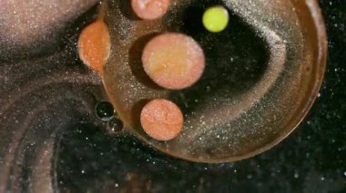 Mürekkep akışı. Köpükler karışır. Odaklanmamış turuncu mor renkli koyu siyah simli yağ emülsiyonu soyut bokeh arka planda yüzüyor..