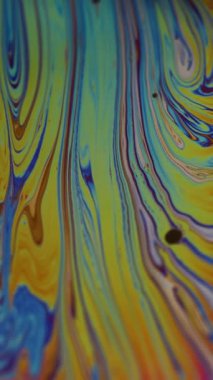 Dikey video. Psikedelik sanat. Yağlı sıvı karışımı. Odaklanmamış mavi mor renkli akıcı boya sıvısı damlası soyut arkaplanda yüzüyor.