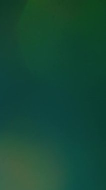 Dikey video. Flaş sızıntısı Retro lens prizması. Koyu arkaplanda parlayan yeşil mavi sönmüş ışık. Eski film ışıldayan ışık huzmesi .