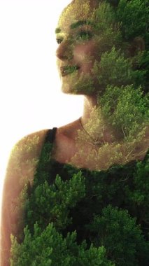 Dikey video. Doğal siluet. Güzellik bakımı. Organik kozmetoloji. Mutlu yeşil ormanda çifte pozlama. Kendine güvenen bir kadın yüzü beyazın üzerinde izole bir şekilde duruyor..