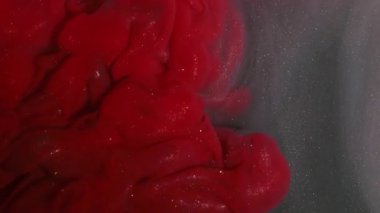 Sparkling paint. Mix ink. Defocused red gray color smoke swirling vapor acrylic shimmer fluid twirling on abstract creative background.