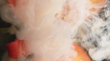 Duman dalgası. Mürekkep sıçradı. Odaklanmamış turuncu zambak çiçeği doğası beyaz duman dumanı soyut koyu siyah botanik arkaplan üzerinde.