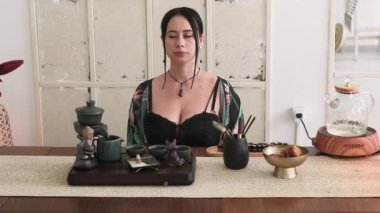 Ruhsal rahatlama. Zihin sükuneti. Kadın bacak bacak üstüne atmış yoga yapıyor aromaterapi meditasyonunun keyfini çıkarıyor mumlarla evde çay seremonisi yapıyor..