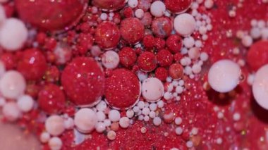 Mürekkep köpüğü karışımı. Boya sanatı. Bulanık kırmızı pembe beyaz renk ıslak lekeler sarı damlacıklar soyut akrilik arka planda yayılıyor.