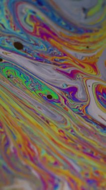 Dikey video. Renk lekesi balonu. Holografik mürekkep. Pembe mavi soyut arkaplanda yüzen yeşil mor akrilik doku..