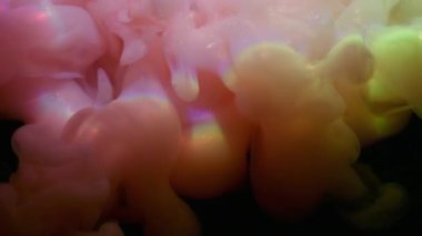 Mürekkep sisi. Gökkuşağı bulutu sıçraması. Odaklanmamış pembe mor parıltılı su parlak neon buhar soyut koyu siyah sanat arka planına yayılıyor..