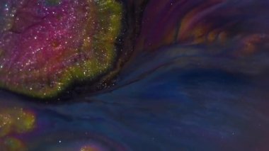 Bulanık mürekkep. Islak doku. Odaklanmamış altın mavisi pembe parlak sıvı soyut sanatın koyu siyah arka planında yüzüyor..