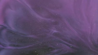 Parıldayan sıvı. Işıldayan sanat. Soyut yaratıcı arka planda yüzen koyu siyah lekelerde çözünmüş pembe mor renk boya..