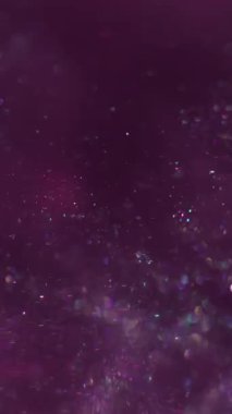 Dikey video. Işıl ışıl. Sanat pırıltısı. Toz akışı karışım mürekkep sisi emülsiyonu. Mor pul rengi parlak desen soyut bulanık scintilla arkaplan.