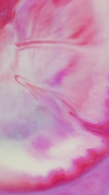 Dikey video. Parlak pigment dalgası. Odaklanmamış boya dokusu. Mor soyut ışıltı arkaplanına yayılan kırmızı beyaz sıvı damlası. Bulanık yuvarlak lens rengi.