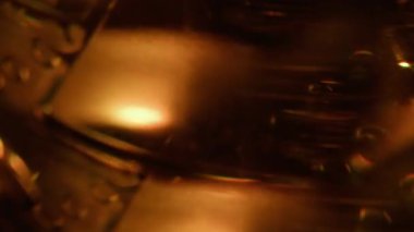 Bulanık turuncu ışık. Parlak bir doku. Altın renkli parlak folyo parıltısı soyut ışıltı arkaplanda ışıldıyor..