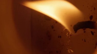 Dikey video. Eriyen mum. Parlak balmumu. Odaklanamayan sarı renk alev çemberi parlak ateş dokusu soyut ışık titreşimli sanat arka planında yanar.