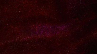 Odaklanamayan parıltı. Parıltılı soyutlama. Mor kırmızı renkli aydınlık parıltı ışıltılı parlak doku sanatın üzerinde yüzüyor koyu siyah bokeh arkaplan.