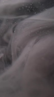 Dikey video. Koyu sis. Grunge dumanı. Gri kıvrımlı sıvı boya kül parçacıkları karışım akışı. Soyut odaklanmış su gece arkaplan dumanı örtüsü.