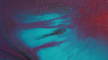 Boyayı yayıyorum. Akrilik doku. Soyut bokeh arkaplanda yüzen mor pembe parlak sıvı pigment..