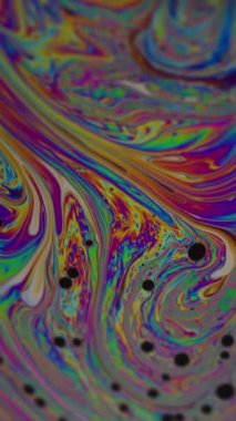 Dikey video. Psikedelik sıvı. Petrol soyutlaması. Odaklanmamış yeşil mor mavi renkli damla mürekkep su dokusu pembe sarı arkaplanda yüzüyor..