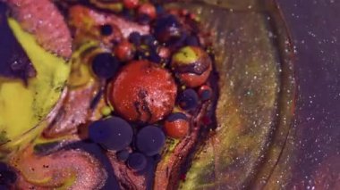 Boya akışı. Bokeh yağı. Soyut akrilik arka planda parlak sıvı boya kabarcıkları oluşturan mor turuncu parlak dokular..