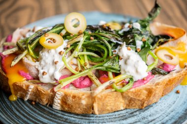 Brunch tostu. Baharatlı yemek. Yaratıcı sebze soslu iştah açıcı sandviç. Pancar sosu kavrulmuş yeşillik kremalı zeytin ekmekli.