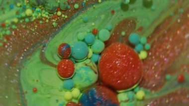 Mürekkep damlası. Suyu boya. Odaklanmamış yeşil mavi parlak yağ sarı turuncu damlacıklar soyut arkaplanda ışıldayan sıvılar