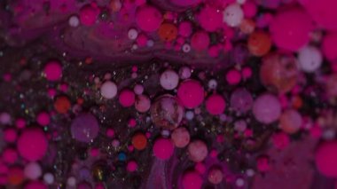 Canlı boya damlası. Sıvı mürekkep. Soyut akrilik sanat arka planında yüzen, pembemsi pembe, kırmızı, köpüklü su damlacıkları..