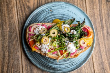Gurme tostu. Besleyici yiyecekler. Zeytin yeşili etli zanaatkar ekmeği tabakta et bırakır. Parlak soslu hardallı porsiyon yemeği..