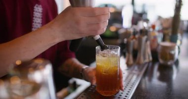 Kokteyl barı. Soğuk kremalı içecek. Barmen soğuk buzlu suya sifonlu krem şanti ekliyor. Kokulu içecek kadehleri hazırlanıyor..