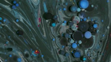 Mürekkep akışı. Köpükler karışır. Soyut sanat akrilik zemin üzerinde yüzen yağ emülsiyonu etrafında sönük mavi mor renk sıvı simler.