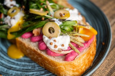 Brunch tostu. Baharatlı yemek. Yaratıcı sebze soslu iştah açıcı sandviç. Pancar sosu kavrulmuş yeşil zeytin ekmeğin üstünde.