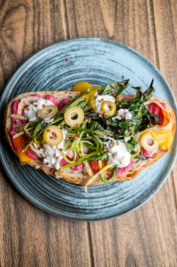 Brunch tostu. Baharatlı yemek. Yaratıcı sebze soslu iştah açıcı sandviç. Pancar soslu yemek, kızarmış yeşillik kremalı zeytin ekmekli..