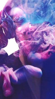 Dikey video. Müzik enerjisi. İlham verici. Pırıl pırıl mor boya, sis bulutu, çift pozlu siluet. Kulaklıkla sesi dinlemekten hoşlanan bir adam..