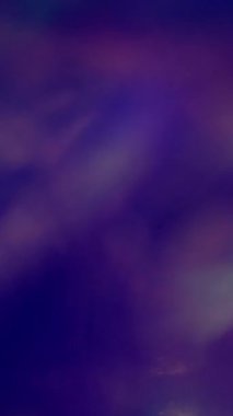 Dikey video. Işık sızıntısı. Neon dağılımlı gradyan. Menekşe mavisi arka planda parlayan ışınlar. Gece renkli soyut fantezi kırılma optik efekti örtüyor.