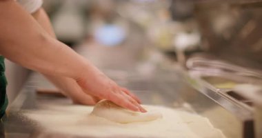 Fırın iş akışı. El yapımı hamur işi. Şef un eleme buğday ezme yumuşak yuvarlak pizza hamuru metal masa üzerinde kenar oluşturur.