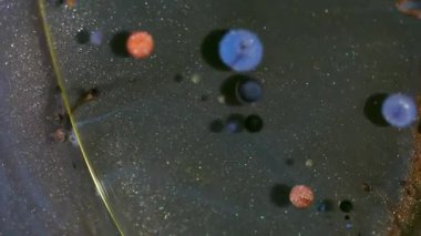 Köpük damlası. Parıldayan sıvı. Odaklanmamış turuncu mavi mor yağ yuvarlak akışı soyut arkaplanda ışkan doku dairesi.