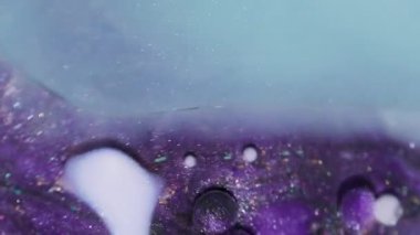 Boya karışımı. Yağ emülsiyonu dökülüyor. Odaklanmamış mor mavi renkli köpük köpükleri soyut arkaplanda parlıyor..