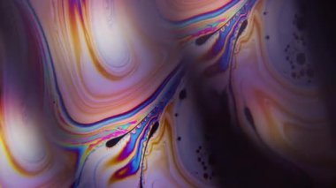 Mürekkep girdabı çözüldü. Yanardağ yağı. Siyah arka planda renkli benzin lambası lensi. Yakıt eğrisi sıvı soyut dokuyu harmanlıyor.