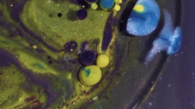 Parıltı emülsiyonu. Yağlı boya topu. Soyut sanat arka planında yüzen köpüklerin etrafında sönük sarı mavi renk parıltı dokusu.