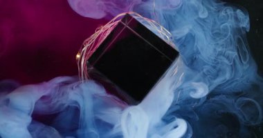 Renkli sis. Elmas çerçeve Cam kristal küpte mavi mor duman karışımı. Açık renk çelenk soyut odaklı olmayan mürekkep koyu arkaplan.